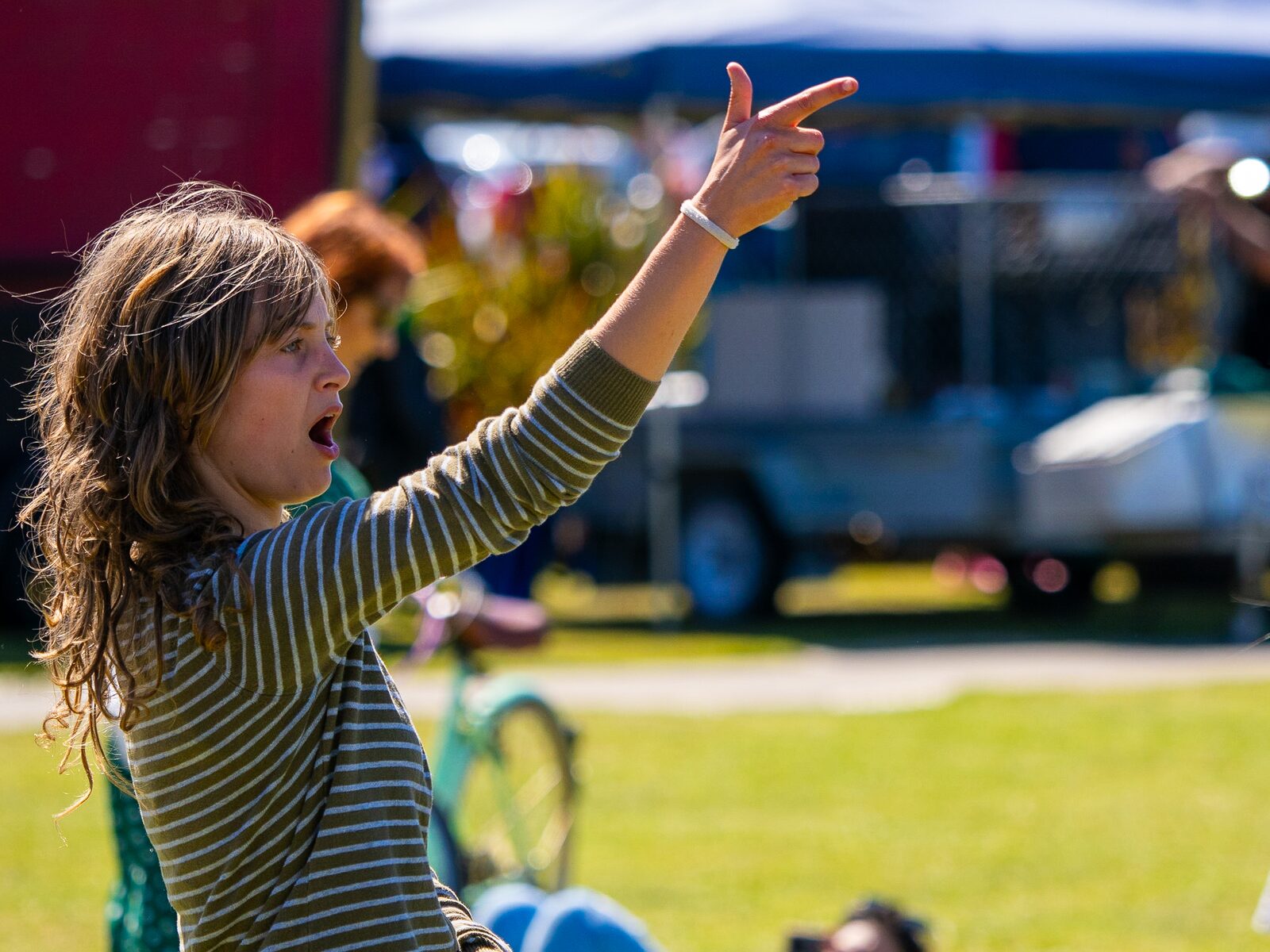 A child dancing with their arms up at the festival